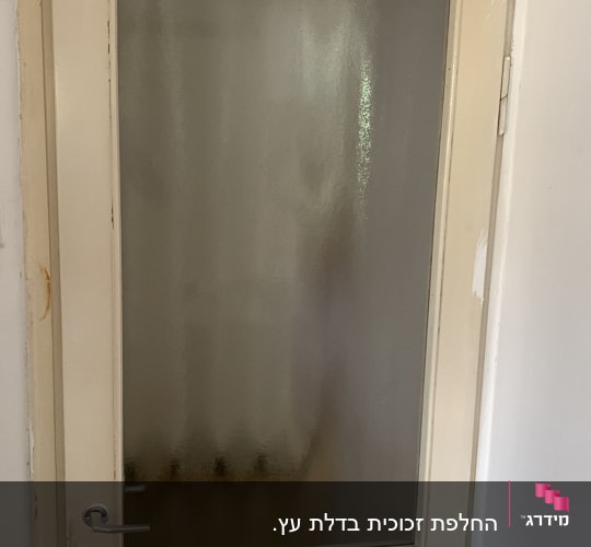 דלת עם זכוכית חלבית במרכז ובחלק התחתון